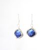Iridescent blue diamond pearl earrings against white background