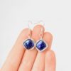 Hand scale photo of blue diamond pearl earrings
