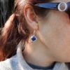 Model wearing the blue wire wrapped geometric pearl dangly earrings