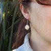 Model wearing dangly ivory pearl eco earrings