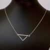 Twisted Arrow Chevron Necklace_Black background scale model