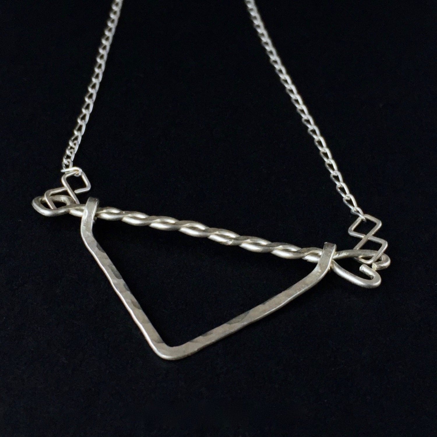 Twisted Arrow Chevron Necklace_Black background Angled Close Up