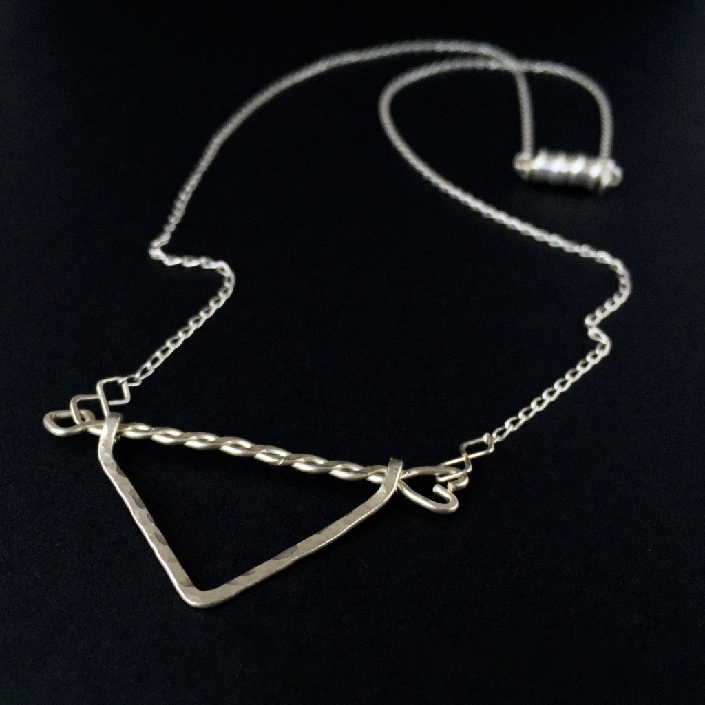 Twisted Arrow Chevron Necklace_Black background Flat Angle View