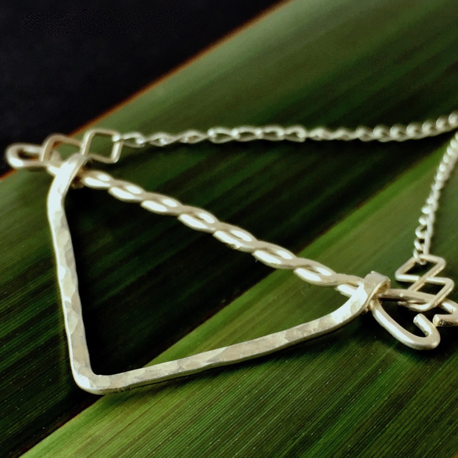 Twisted Arrow Chevron Necklace_Flax background Angled Close Up