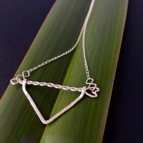 Twisted Arrow Chevron Necklace_Flax background