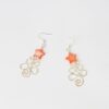 Flatlay of Christmas Tree earrings with red star against white background