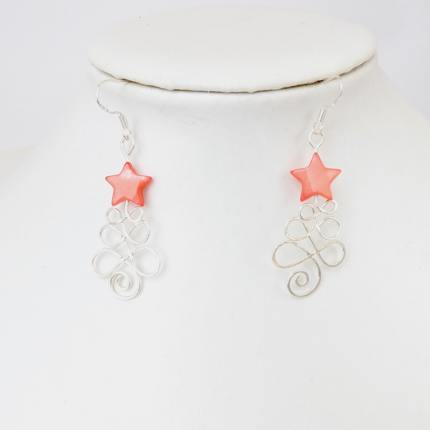 Red star Christmas tree earrings hung on white neck model