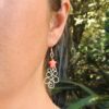 Wire wrapped Christmas Tree Earrings with red Mother of Pearl Star worn on the model