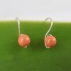 Front view of orange coral Swarovski Pearl small drop earrings