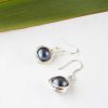 Angled view of black freshwater pearl earrings wire wrapped in eco silver
