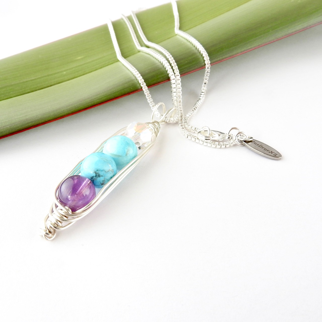 Angle view of customised birthstone necklace for April, 2 x December and February