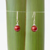 Burgundy Christmas Bauble Earrings_Flax Burgundy Swarovski Pearl Christmas bauble earrings against flax