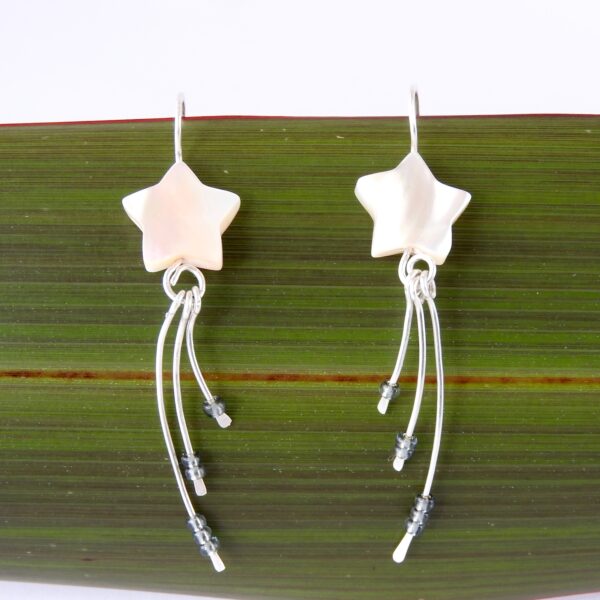 Mother of Pearl Wishing Star Eco Earrngs Close up of Wishing Star Earrings against flax background