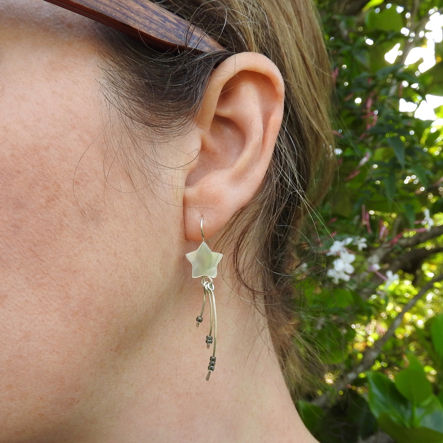 Shooting star earrings with three dangles being worn by model