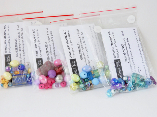 A selection of kids bracelet making kits ready to be put in their organza bags