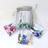 selection of different coloured kids bracelet making kits in their organza bags