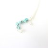 Kids letter C necklace with turquoise stones, site on a silver plated shorter necklace