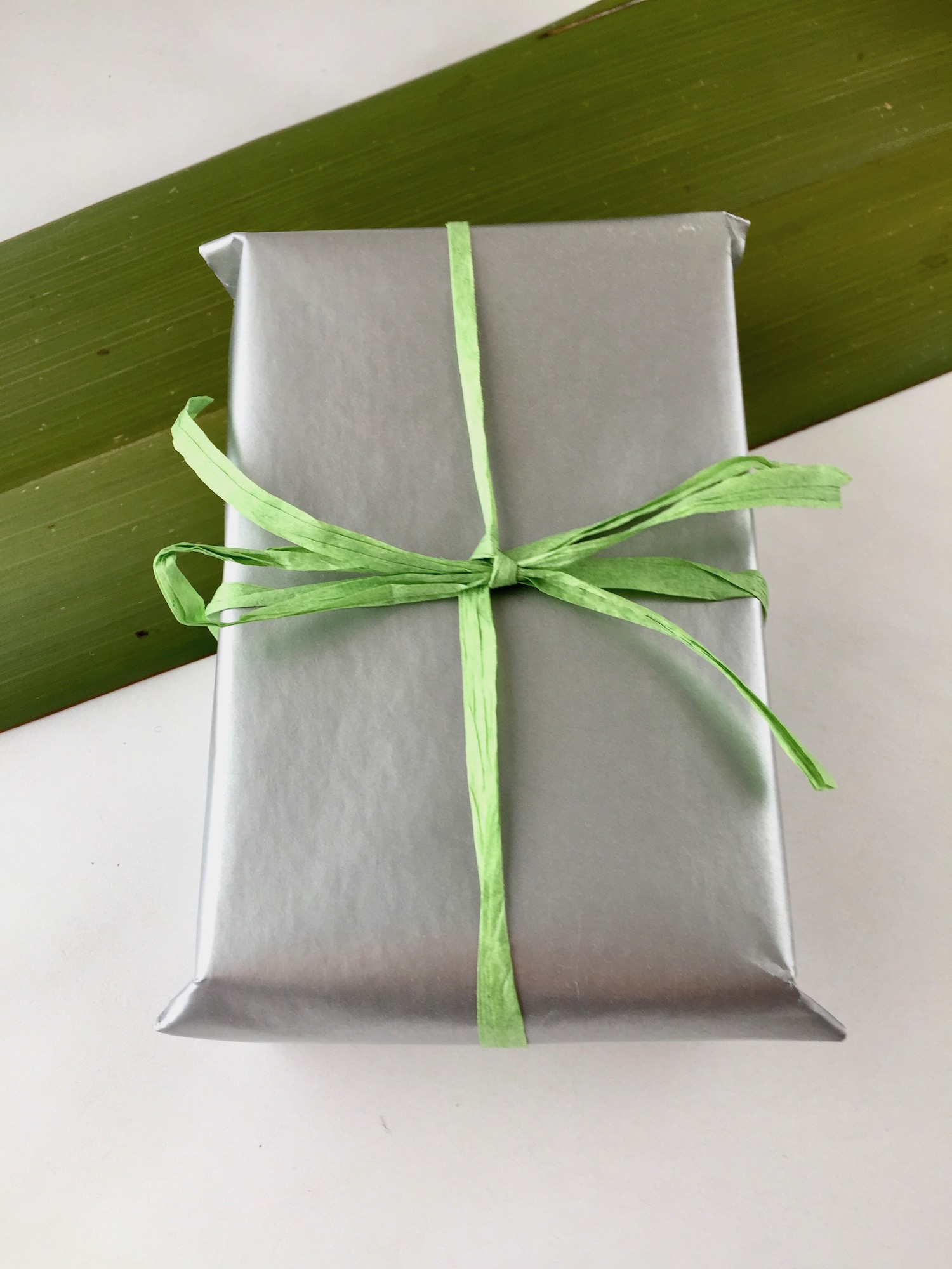 Gift wrapped box with green paper ribbon