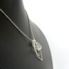 Left side angled view of ring on holder necklace