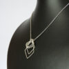Side angled view of ring on holder necklace