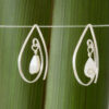 Mother of Pearl Tear Drop Limited Edition 10th biz birthday earrings, shown front on in front of flax