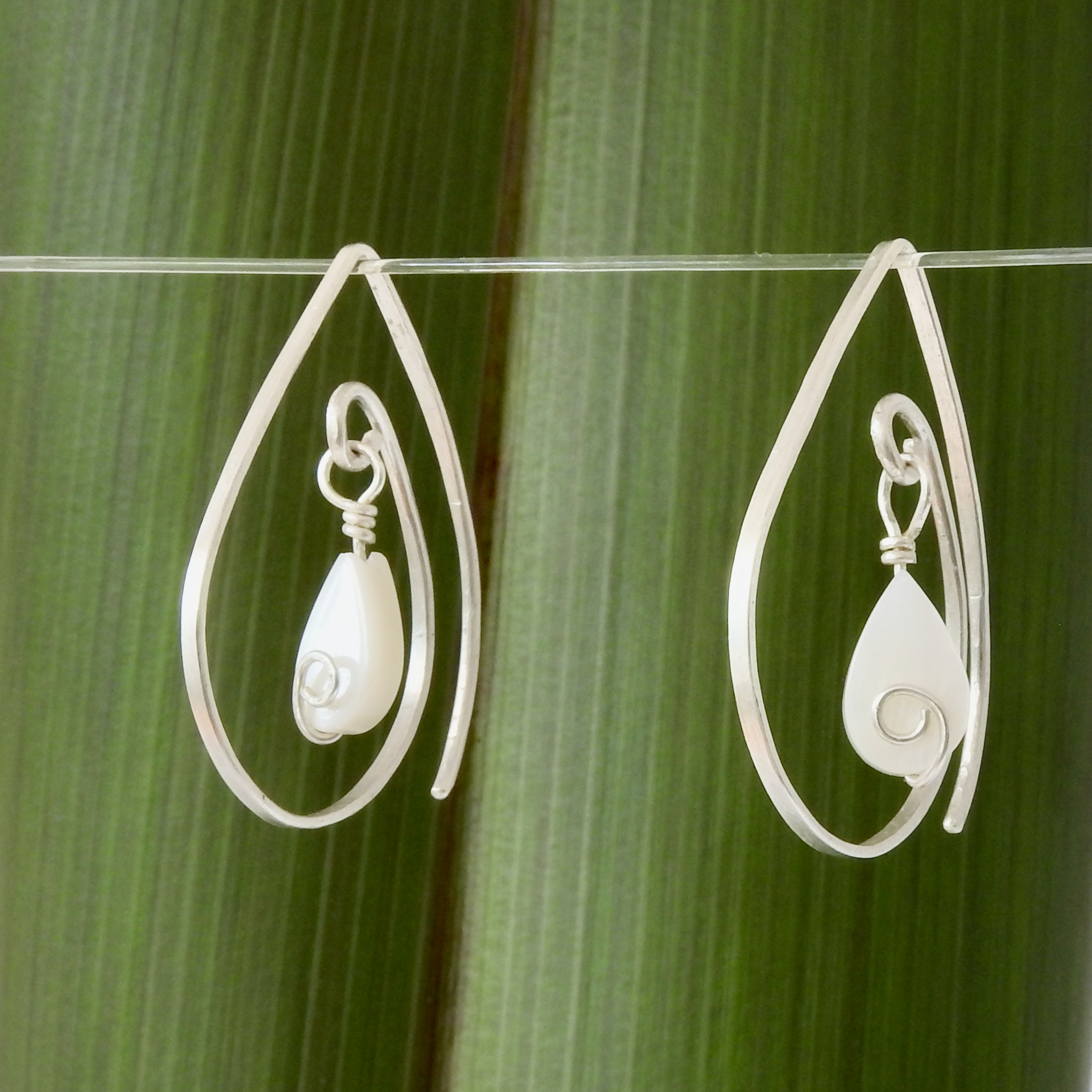 Limited Edition Mother of Pearl Eco Silver Tear Drop earrings_hanging against flax