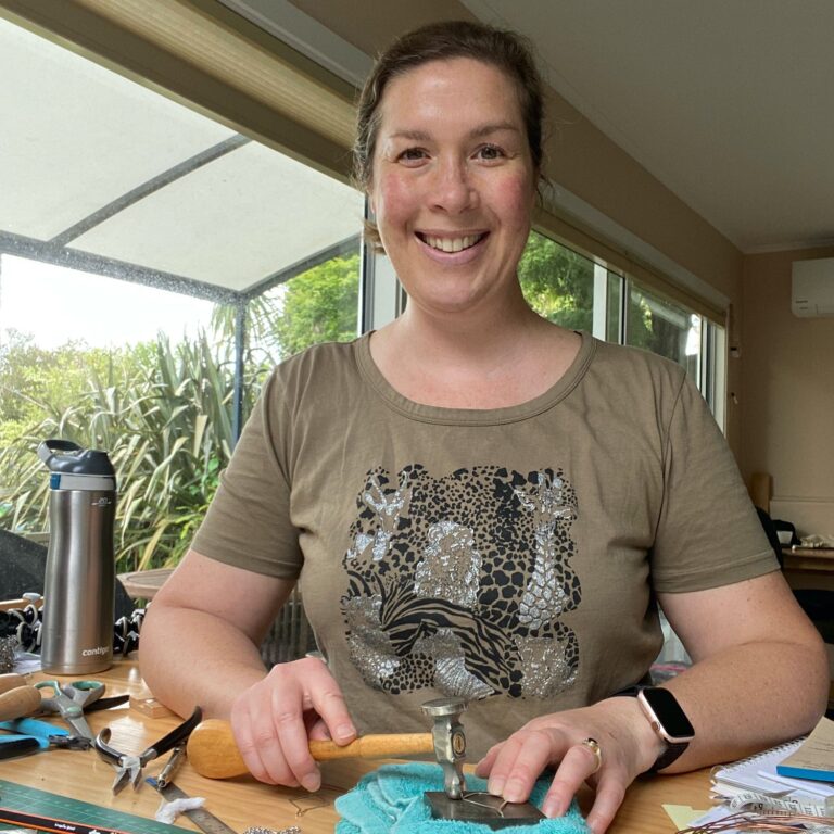 Me - Suzie Horne - Making and hammering a silver jewellery piece at my desk in my home studio