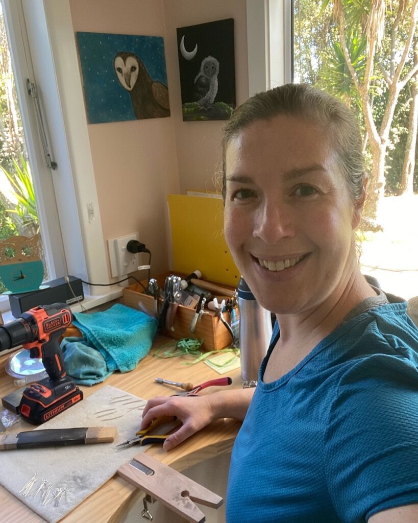 Suzie sitting at her desk overlooking her garden, hand-making recycled sterling silver earring hooks