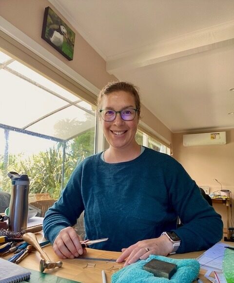 Suzie Horne sitting in her downstairs solar-powered studio, making some jewellery