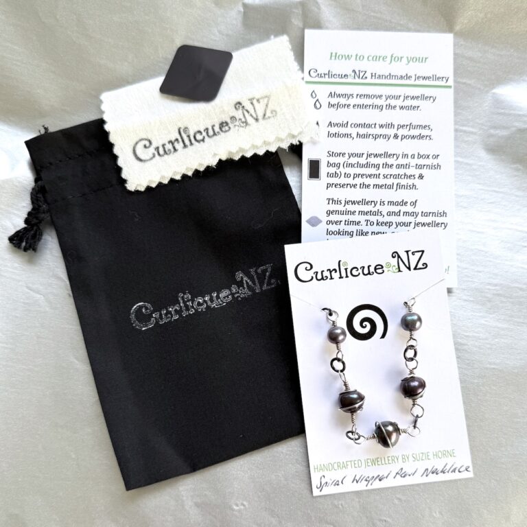 Image showing what's included inside your packaged item: your jewellery product on card, a Care Card, an Anti-tarnish tab, a polish cloth (product dependent). This all sits within a cotton bag, which is then wrapped in Silver tissue paper and tied with cotton cord, a sticker and a gift tag if requested.